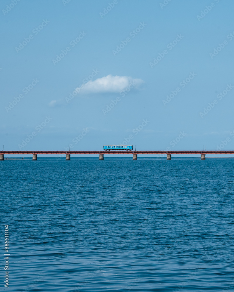 Train crossing a bridge on the sea