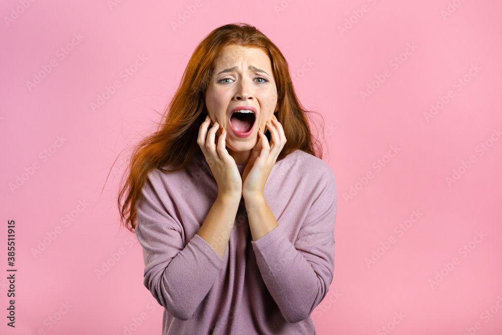 Frightened and screaming woman shocked isolated over pink background. Stressed and depressed pretty girl because of bad news. Frightened and screaming woman shocked isolated over pink background. Stressed and depressed pretty girl because of bad news.