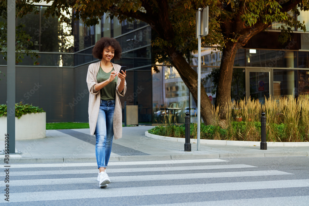 Woman with mobile phone crossing the street Woman with mobile phone crossing the street
