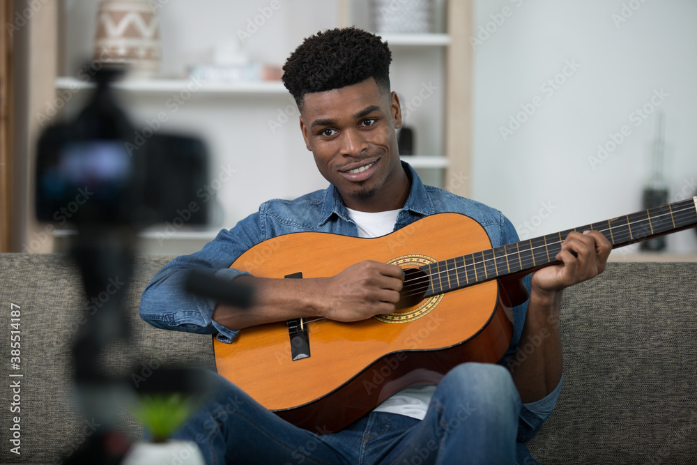 Obraz premium musician playing a guitar before a recording camera