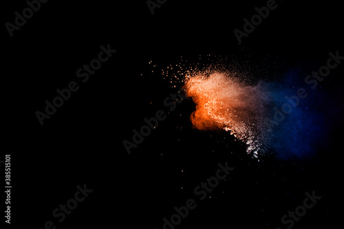 Orange blue color powder explosion on black background.