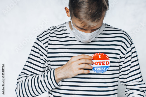 young man holding I voted today sticker. November elections in the United States 2020 during Covid pandemic. man in face mask