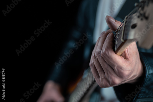 Guitarist hands and guitar strings close up.