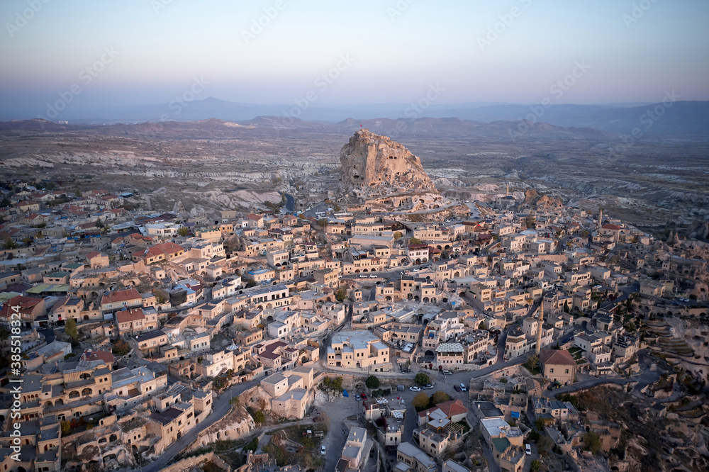 Top view of the city of Ortahisar at sunset. Panoramic view of castle and ancient houses. Cappadocia, Turkey.
