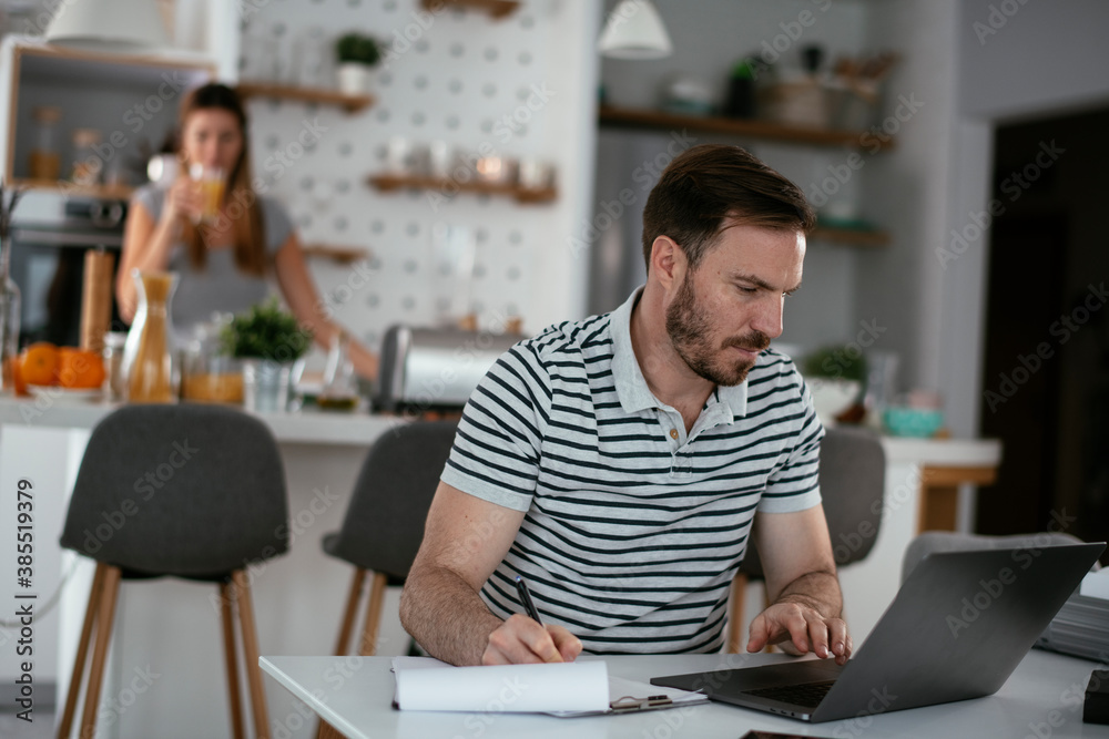 Fototapeta premium Young man working on project. Handsome man working at home.
