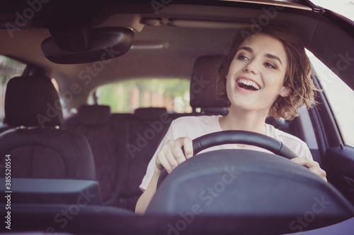 Photo of positive cheerful girl ride drive car traffic road route look front window see her friend stay in city center