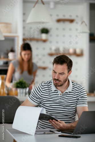 Young man working on project. Handsome man working at home.