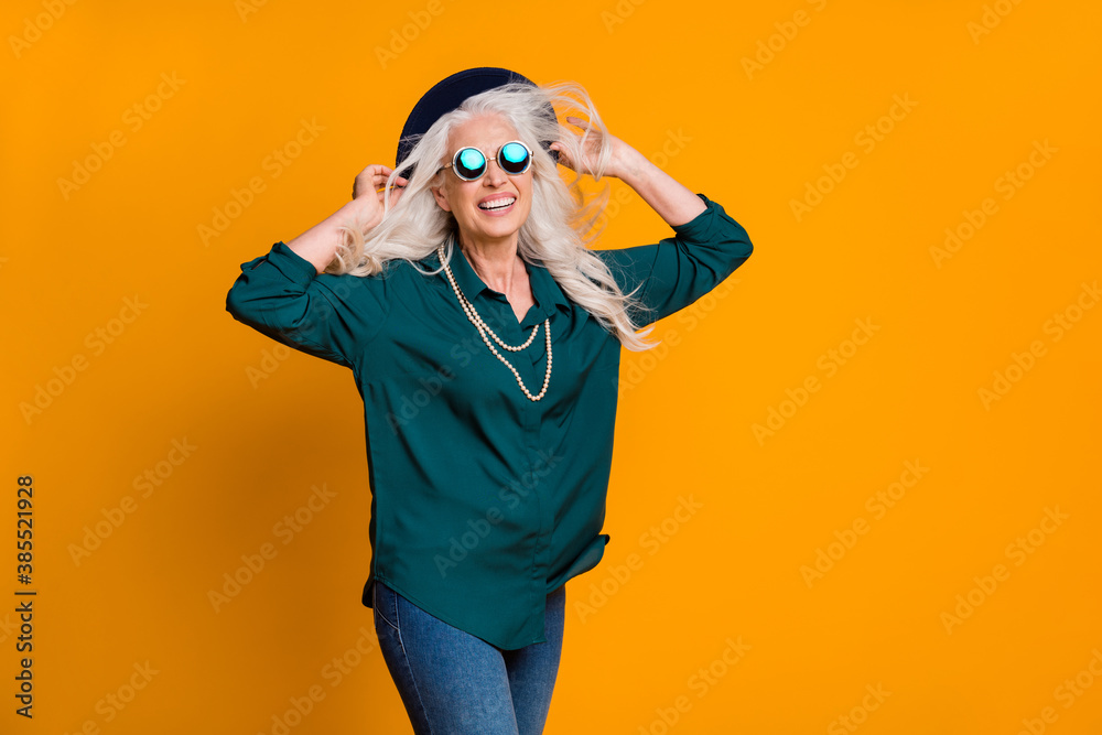 Photo of pretty funny white haired grandma lady walk street enjoy season breeze wear green shirt sun specs necklace jeans retro hat isolated bright yellow color background Photo of pretty funny white haired grandma lady walk street enjoy season breeze wear green shirt sun specs necklace jeans retro hat isolated bright yellow color background