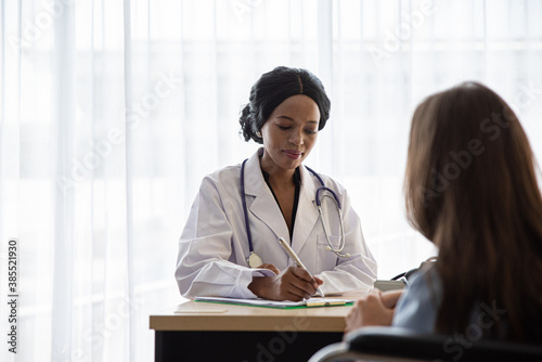 Doctor And Patient Discussing While Sitting At Hospital
