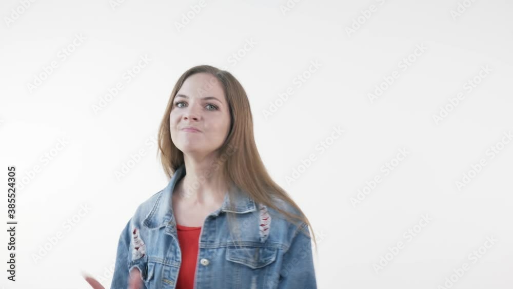 Angry girl screams, gets angry and looks at the camera. Long beautiful hair. White background. Angry girl screams, gets angry and looks at the camera. Long beautiful hair. White background.
