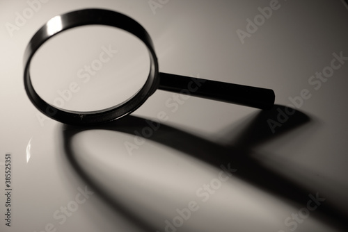 Magnifying glass with abstract shadow,  black and white close up