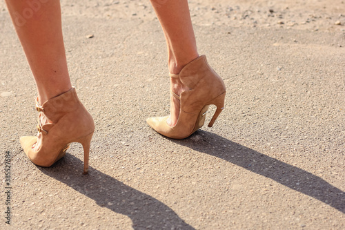 Broken stiletto heel on the shoes wearing by attractive young woman.