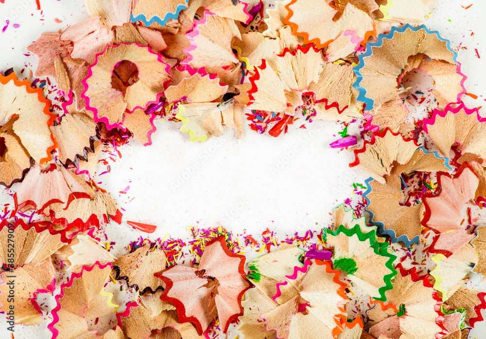 Flat lay view of colorful wooden pencil shavings with white copy space in center. Studio shot. Flat lay view of colorful wooden pencil shavings with white copy space in center. Studio shot.