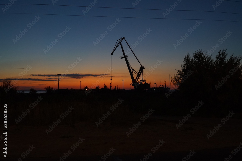 Crane in the port at dusk. Sunset sky.