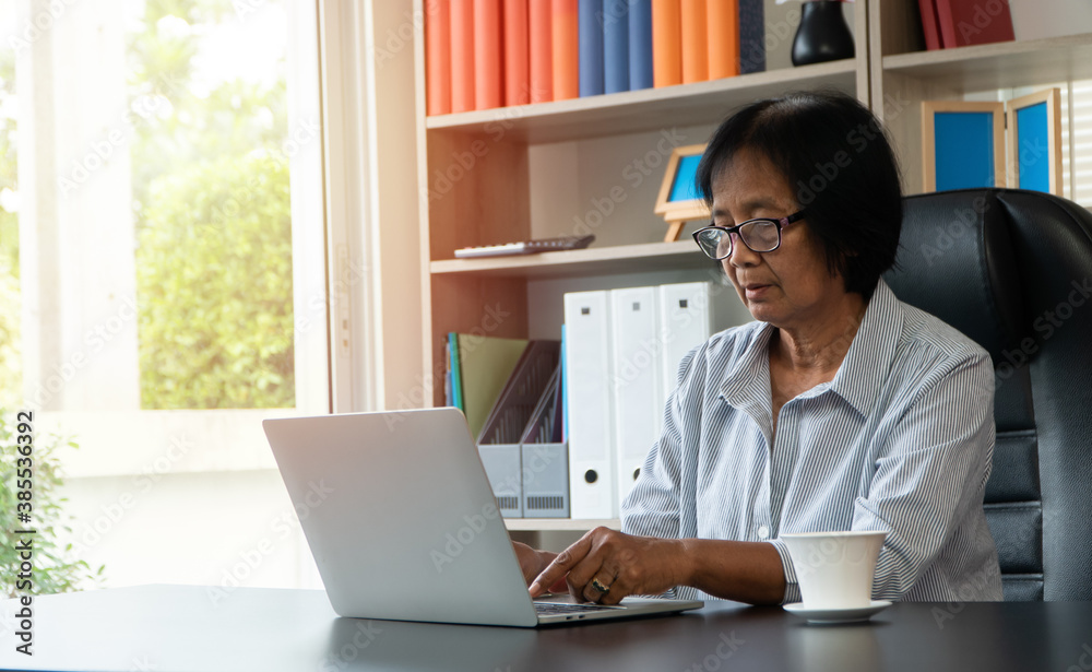 Happy senior Asian using the laptop for calculating and make a note of daily expenses. Concept of lifestyle, learning, and finance business Happy senior Asian using the laptop for calculating and make a note of daily expenses. Concept of lifestyle, learning, and finance business