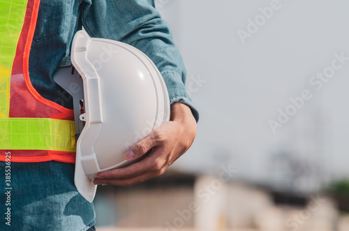 White safety helmet is in the hands of an engineer.