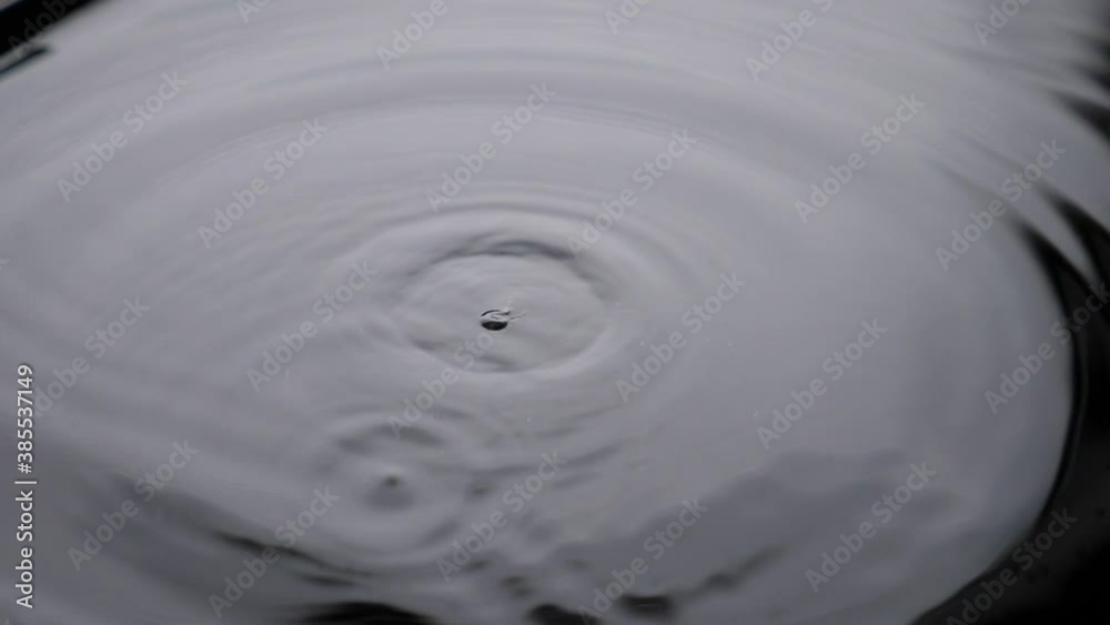 Water drop drips to liquid surface Full HD slow-motion video nature abstract background. Waterdrop falling and splashing with radial circle waves Water drop drips to liquid surface Full HD slow-motion video nature abstract background. Waterdrop falling and splashing with radial circle waves
