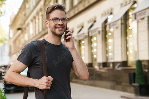 Smiling attractive young man talking on mobile phone