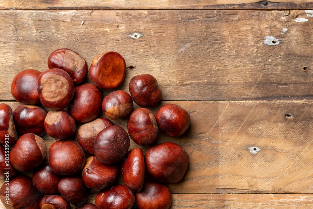 Photograph of Horse Chestnuts, Conkers arranged on a rustic wooden background shot from above with copy space. Autumn, fall, winter concept Photograph of Horse Chestnuts, Conkers arranged on a rustic wooden background shot from above with copy space. Autumn, fall, winter concept