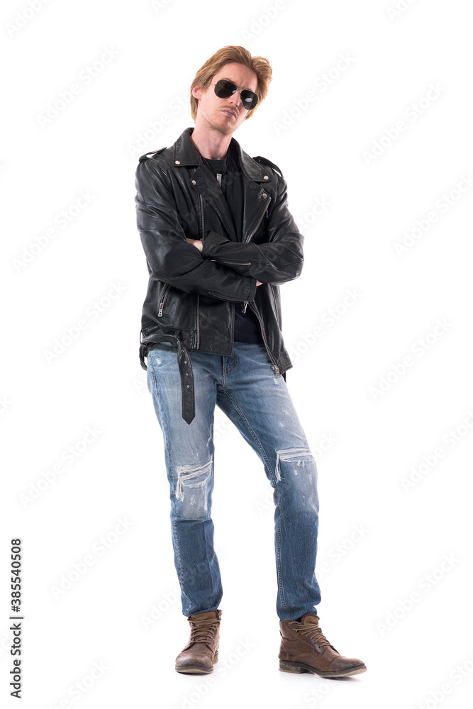 Serious confident stylish man in rocker or biker clothes looking at camera with crossed hands. Full body isolated on white background. Serious confident stylish man in rocker or biker clothes looking at camera with crossed hands. Full body isolated on white background.