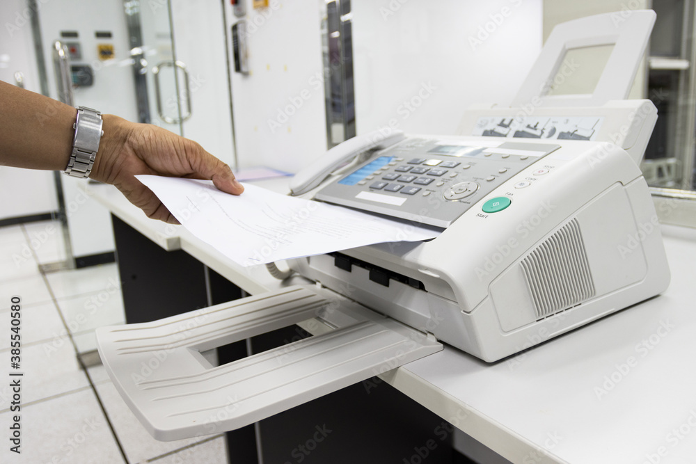 hand man are using a fax machine in the office, equipment for data transmission. hand man are using a fax machine in the office, equipment for data transmission.