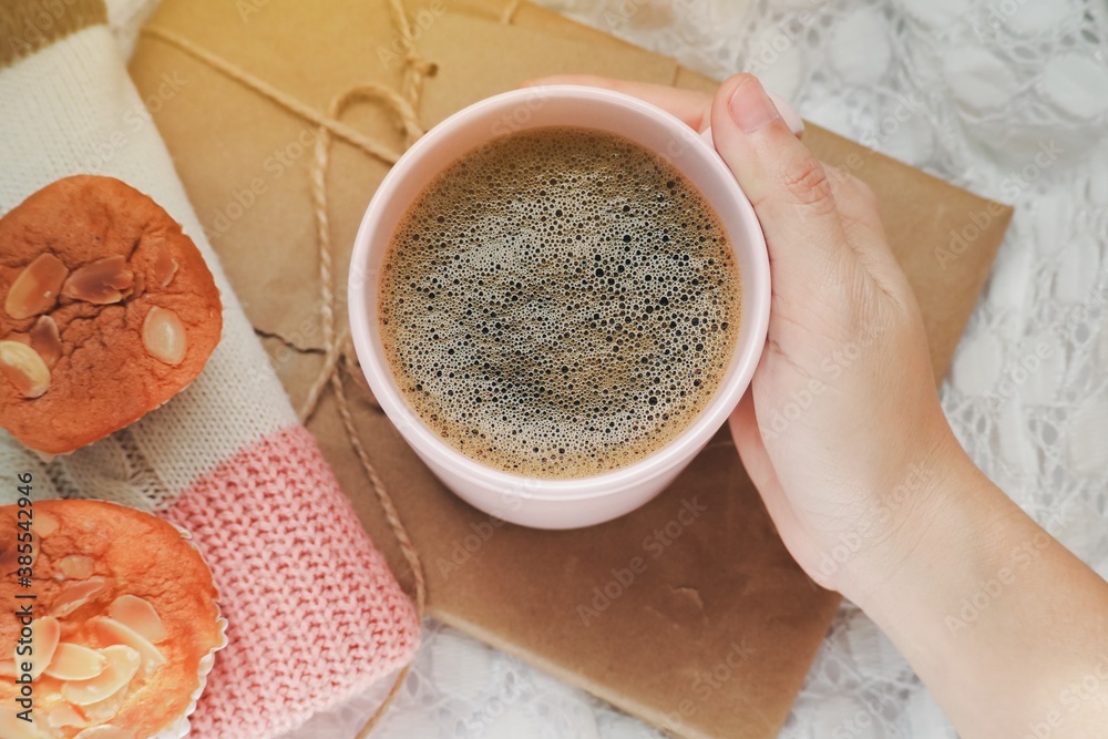 coffee top view. White woman's hand holding coffee pink cup on gift box brown with bakery and Sweater on white background. morning time winter concept. coffee top view. White woman's hand holding coffee pink cup on gift box brown with bakery and Sweater on white background. morning time winter concept.