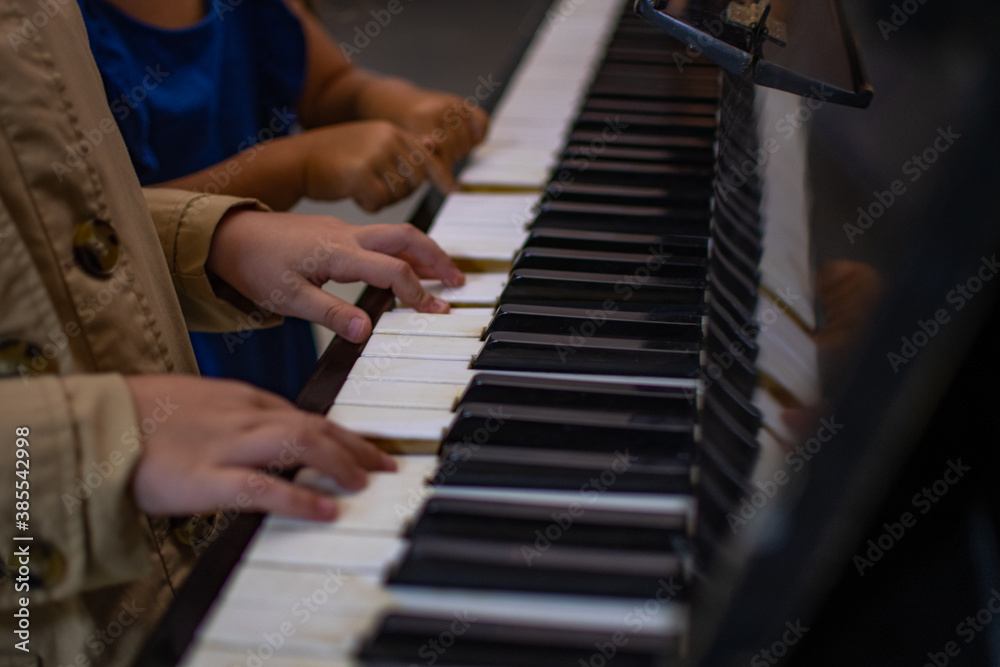Close up of children hands playing the piano