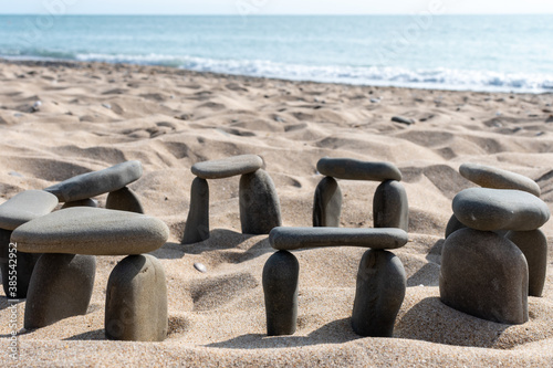 Natural background of a bunch of stones on a sandy surface in front of the blurry image of the mediterranean sea