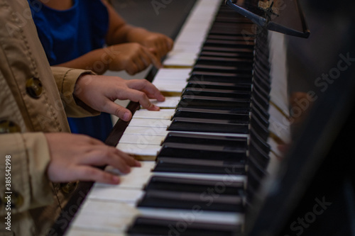 Close up of children hands playing the piano