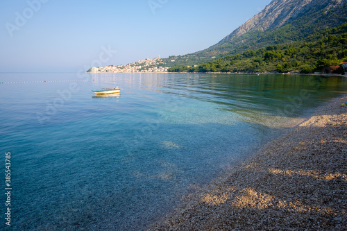 small boat on the sea, empty beach, zivogosce, croatia photo