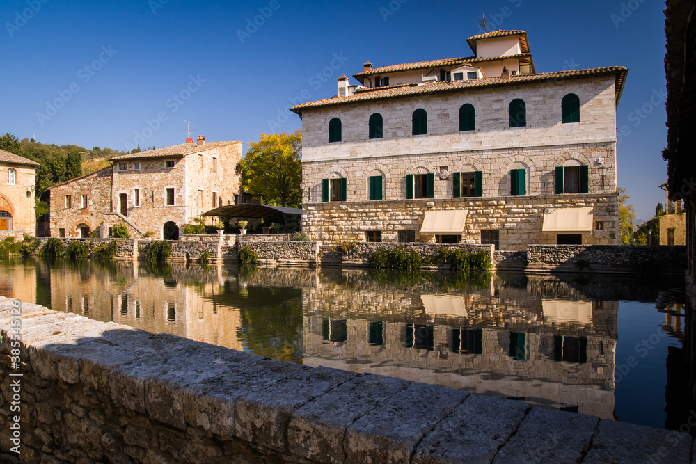 roman old house with water reflection, tuscany, italy