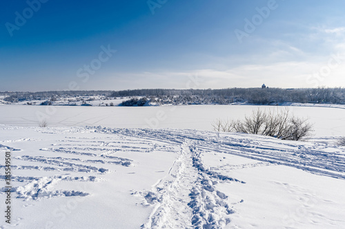 Spacious snow landscape. River and hills in Russia, white winter on the terrain, a lot of fluffy snow and ice under a beautiful blue sky. Rostov region, town of Shakhty, the river Grushevka 