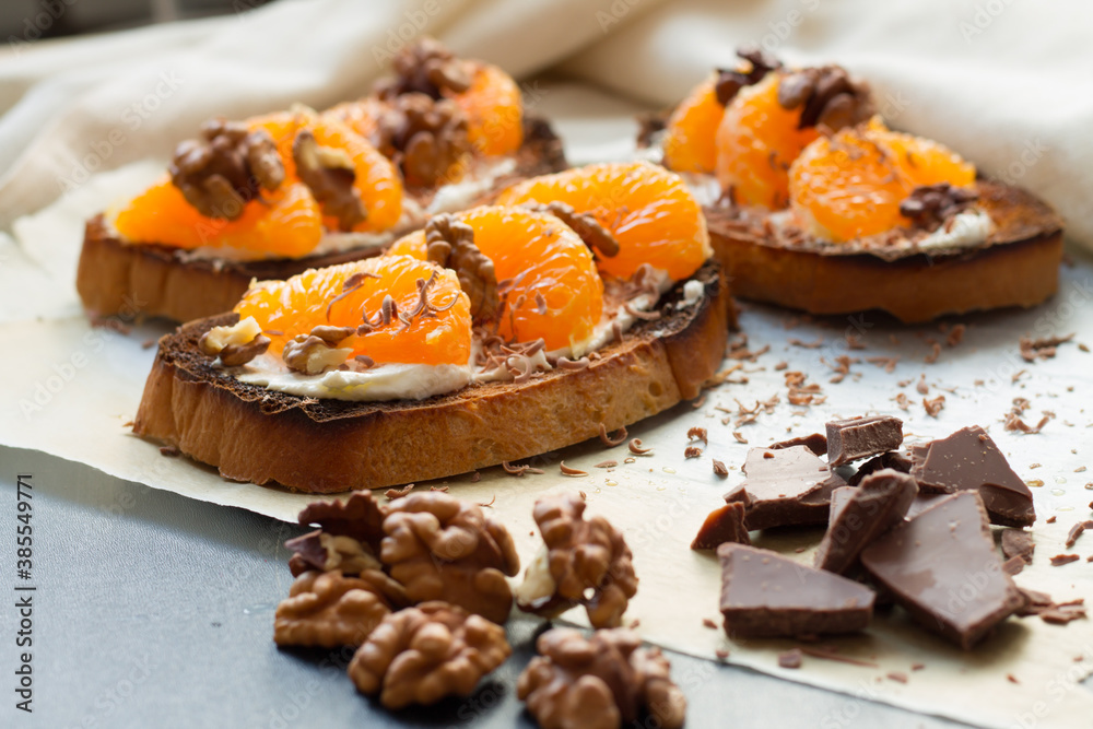 Delicious toast with sweet tangerine on black wood background Delicious toast with sweet tangerine on black wood background