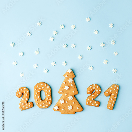 Happy New Year's set of numbers 2021 from ginger biscuits and tree glazed sugar icing decoration on blue background, minimal seasonal winter holiday card, banner, flyer, coupon, stay home