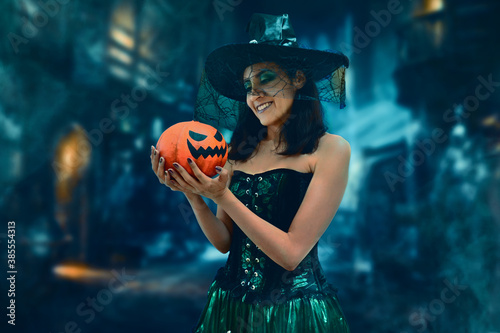 Young witch with pumpkin to halloween photo