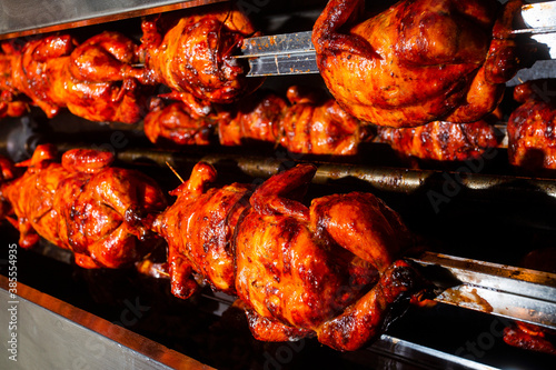 Slika na platnu Barbecue roast Chicken in a row turning at industrial roaster
