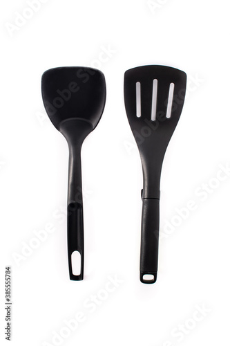 Black plastic kitchen spatula and spoon isolated on white background	