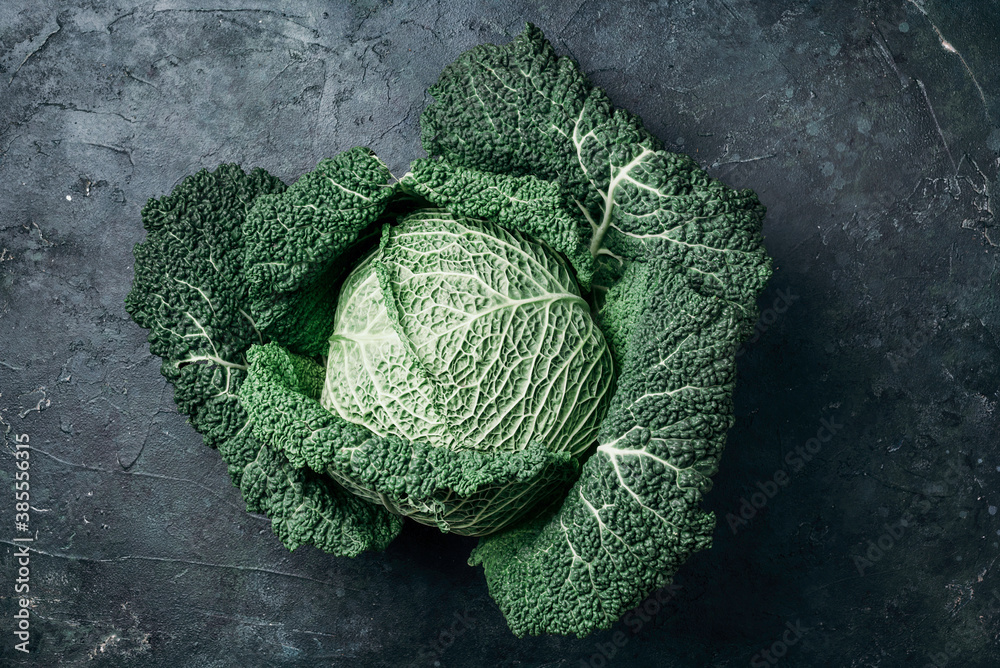 Fototapeta premium Raw green cabbage texture. Organic savoy cabbage on dark background. Top view. Copy space. Vegan and vegetarian diet concept