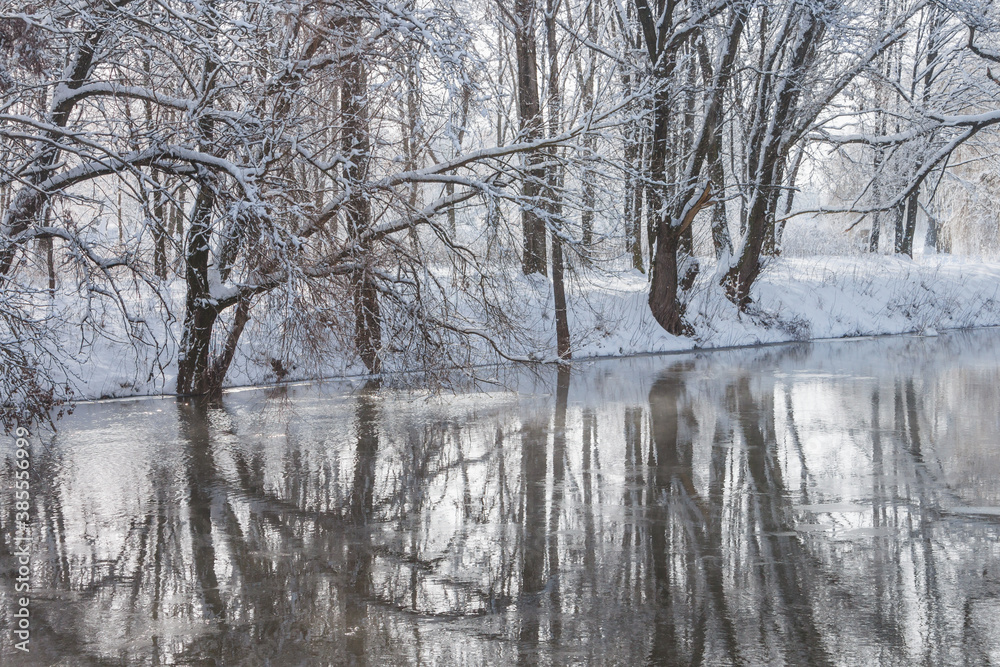 Winter river with snow-covered shores and trees. Winter landscape Winter river with snow-covered shores and trees. Winter landscape