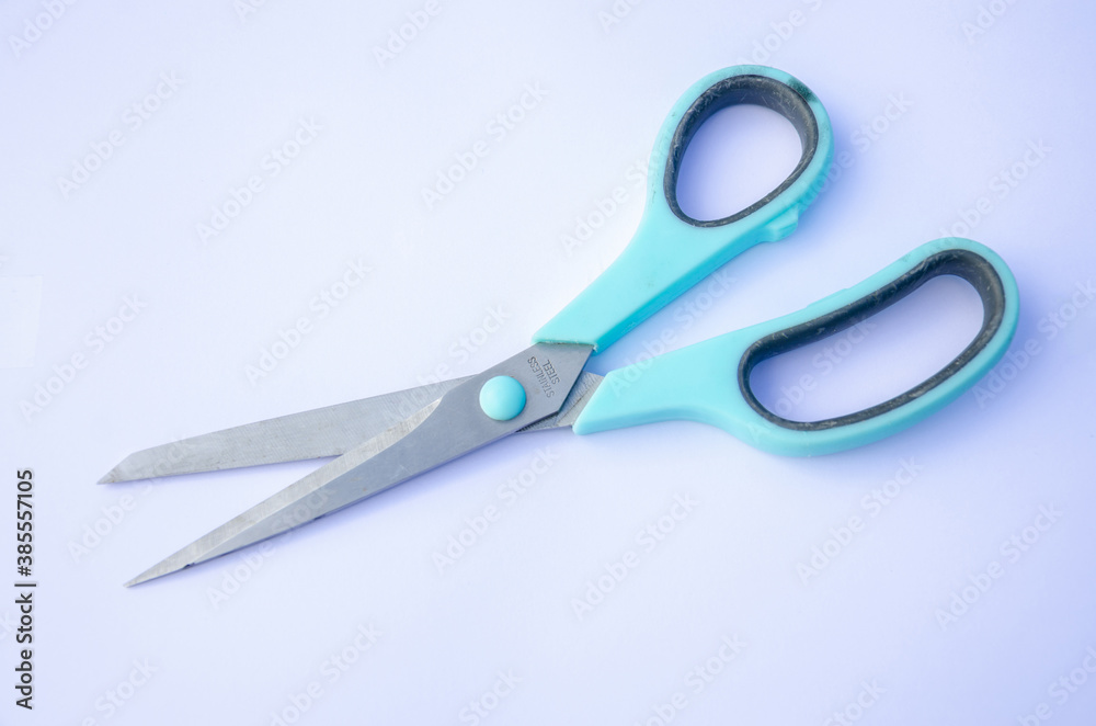A pair of stainless steel scissors on a white background. A pair of stainless steel scissors on a white background.