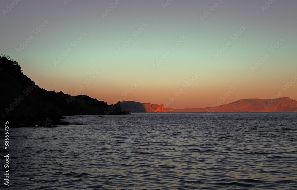 seascape with mountains at sunset