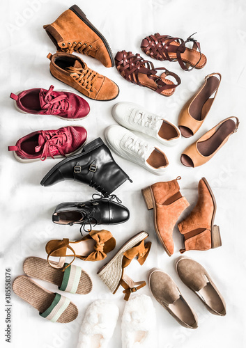 Variety of women's fashion comfortable shoes of all seasons on a light background, top view