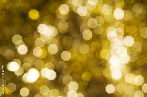 Christmas and New Year holidays blurred golden sparkles background, abstract background with bokeh defocused glittering lights and shadow © Digihelion