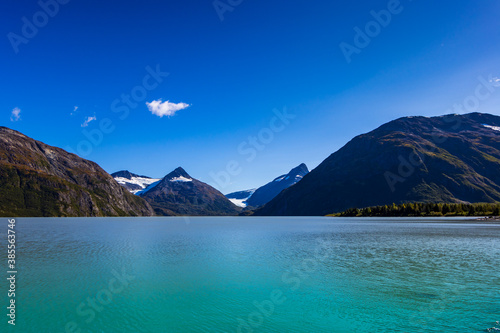 Portage Lake, a turquoise blue glacial lake in a fjord near Whittier, Alaska. The Chugach Mountains are in the distance.
