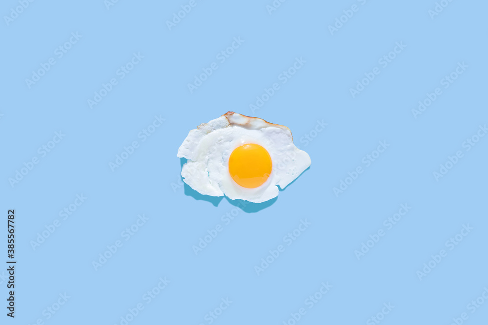 Fried eggs on a light blue background. Minimalism, top view. Breakfast concept, fried food. Fried eggs on a light blue background. Minimalism, top view. Breakfast concept, fried food.