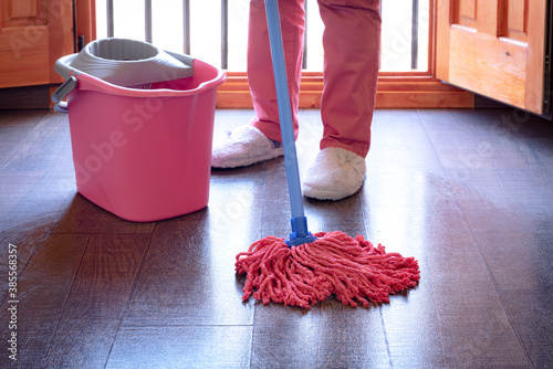 Mujer limpiando el suelo con una fregona photo