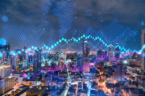 FOREX graph hologram, aerial night panoramic cityscape of Bangkok, the developed location for stock market researchers in Asia. The concept of fundamental analysis. Double exposure.