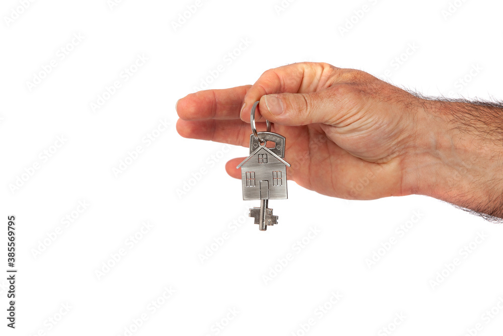 Man's hand giving a new metal key with home shaped keychain, isolated. New home concept