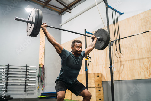 Crossfit athlete doing exercise with a barbell.