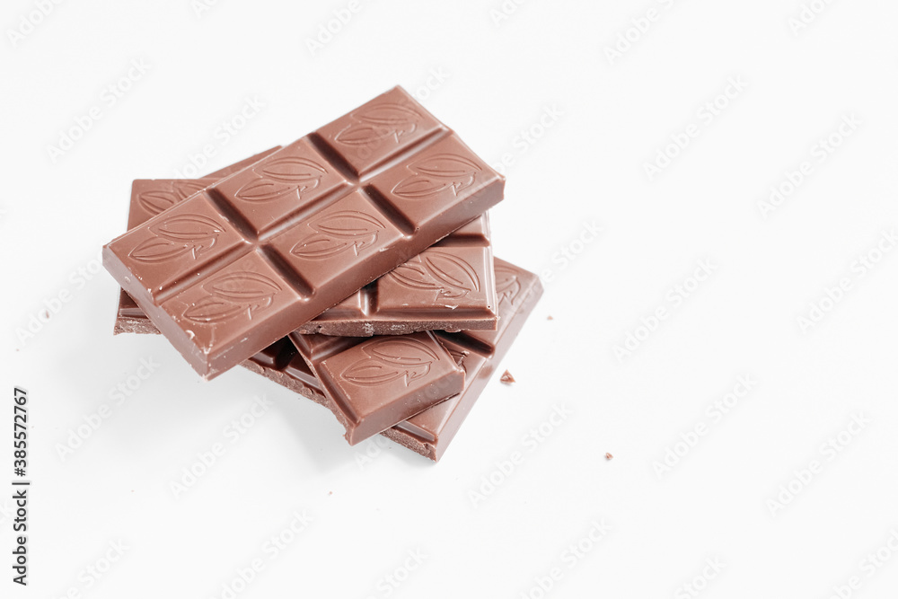 Milk chocolate pieces isolated on white background from top view, close up a chocolate bar isolated on white background